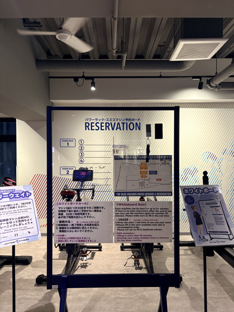 Reservation board for two power racks at Anytime Fitness Meguro